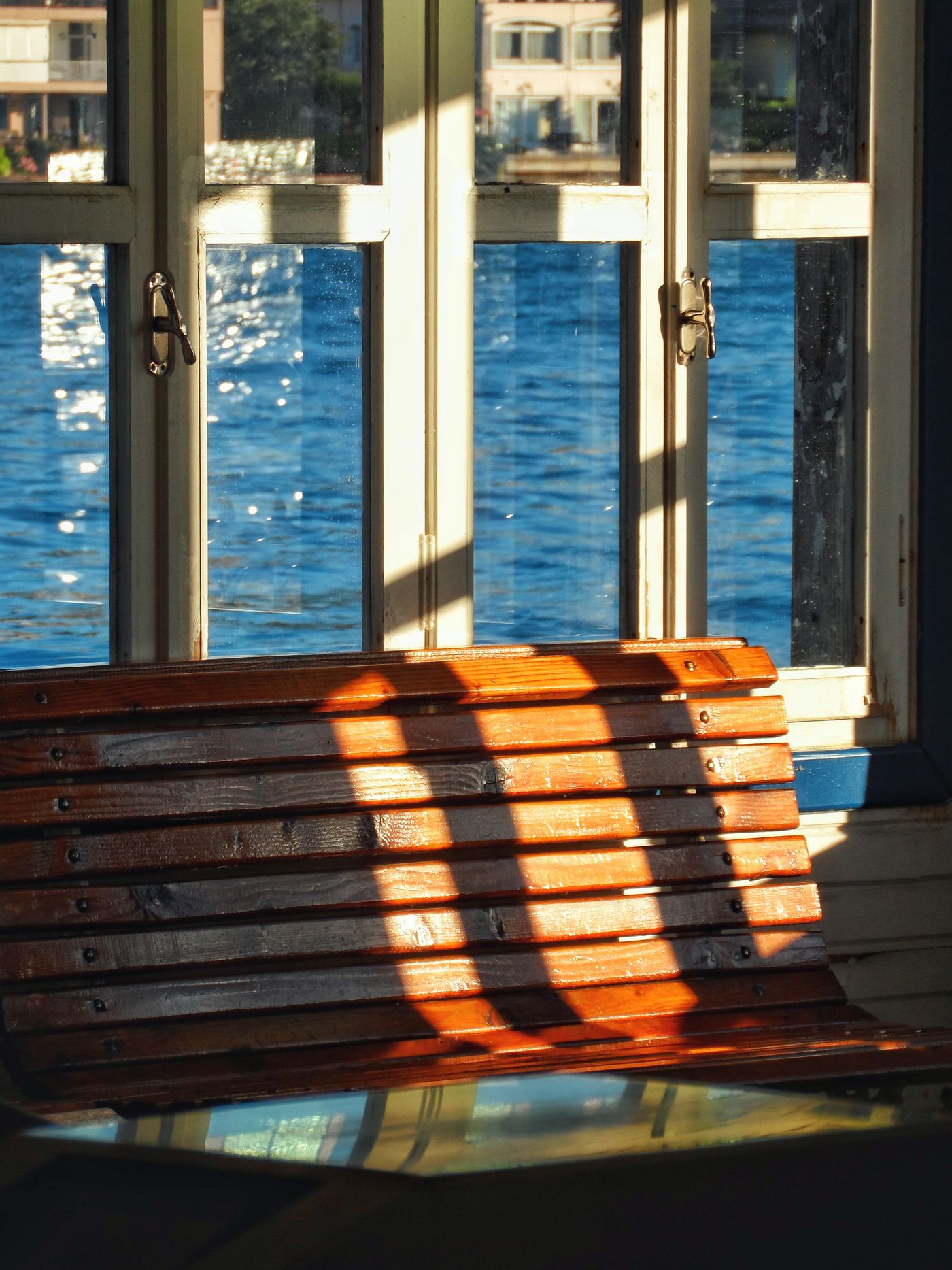 A wooden bench beside a window