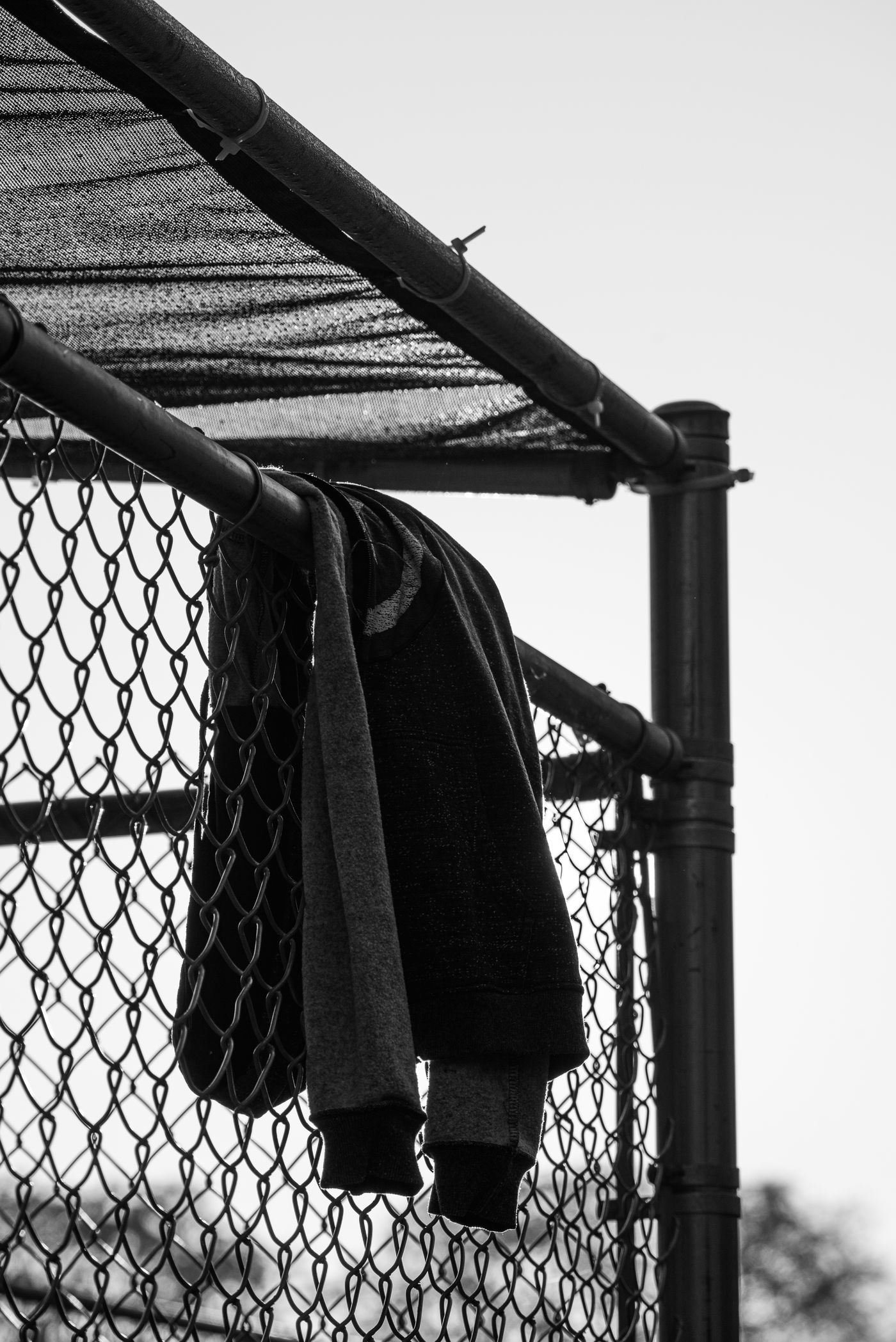 A hoodie hanging on a fence